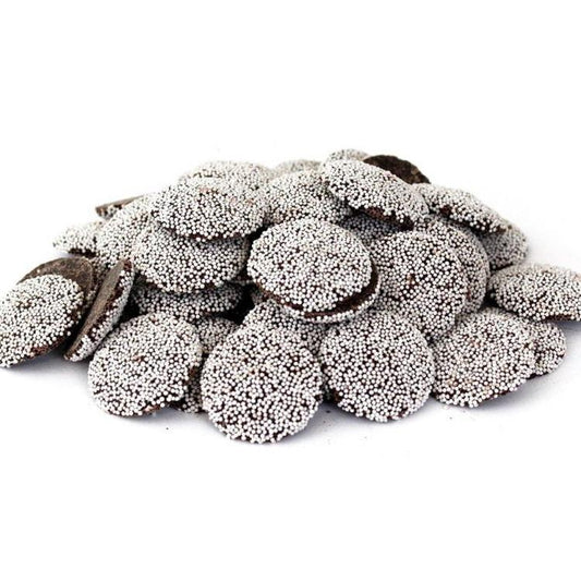 A pile of dark chocolate nonpareils on a clean white background