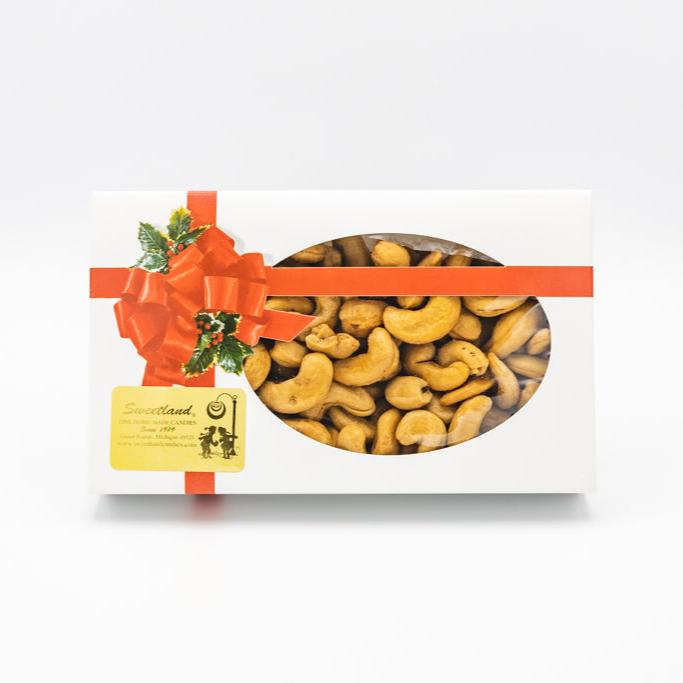 A box of roasted salted colossal cashews adorned with a decorative bow on top, ready for gifting or enjoying