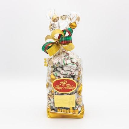 A festive bag of white chocolate Christmas tree pretzels, adorned with a ribbon and a decorative bow