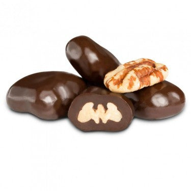 Dark chocolate-covered pecans on a white background