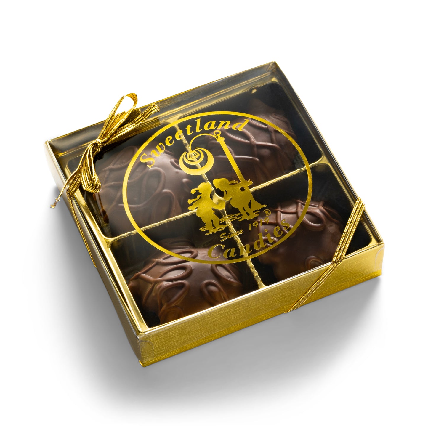 A gold gift box with 4 milk chocolate turtle candies