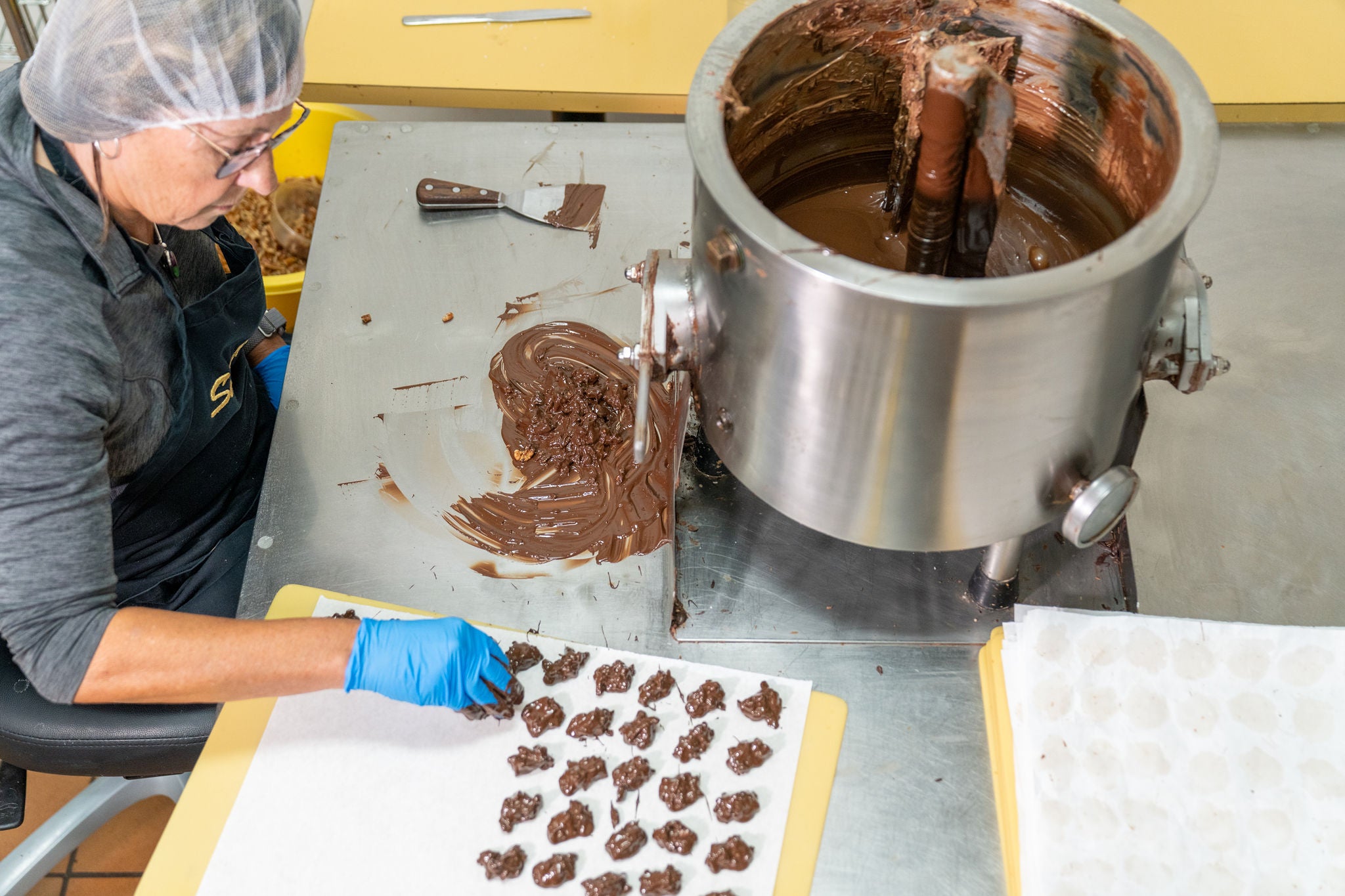 Person working with chocolate in a factory setting