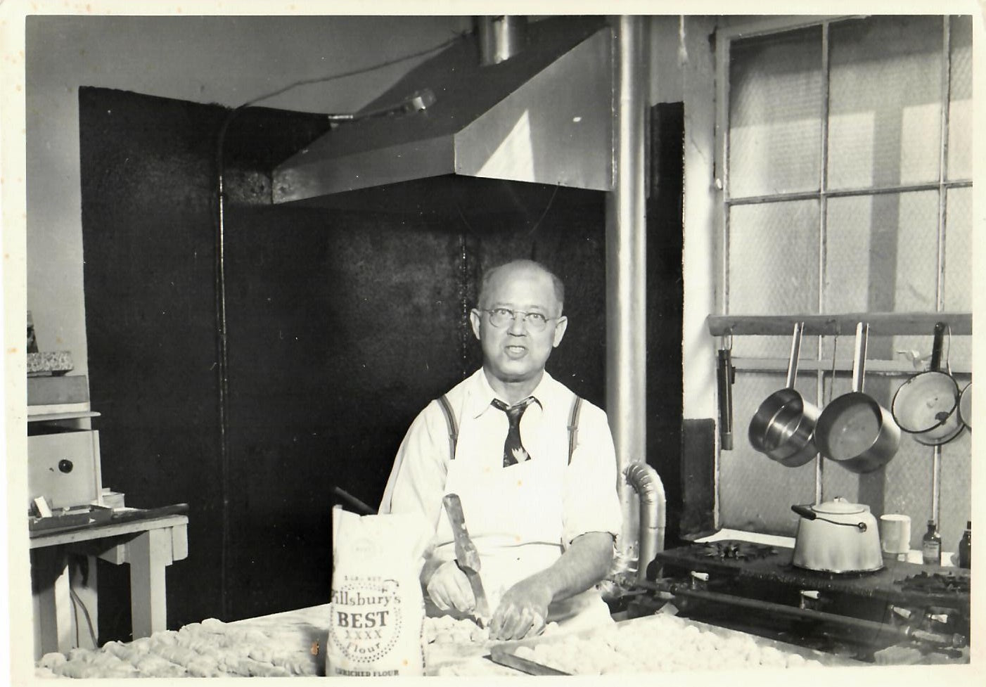 Historic photo of Chris Naum of Sweetland Candies preparing sweets in a kitchen