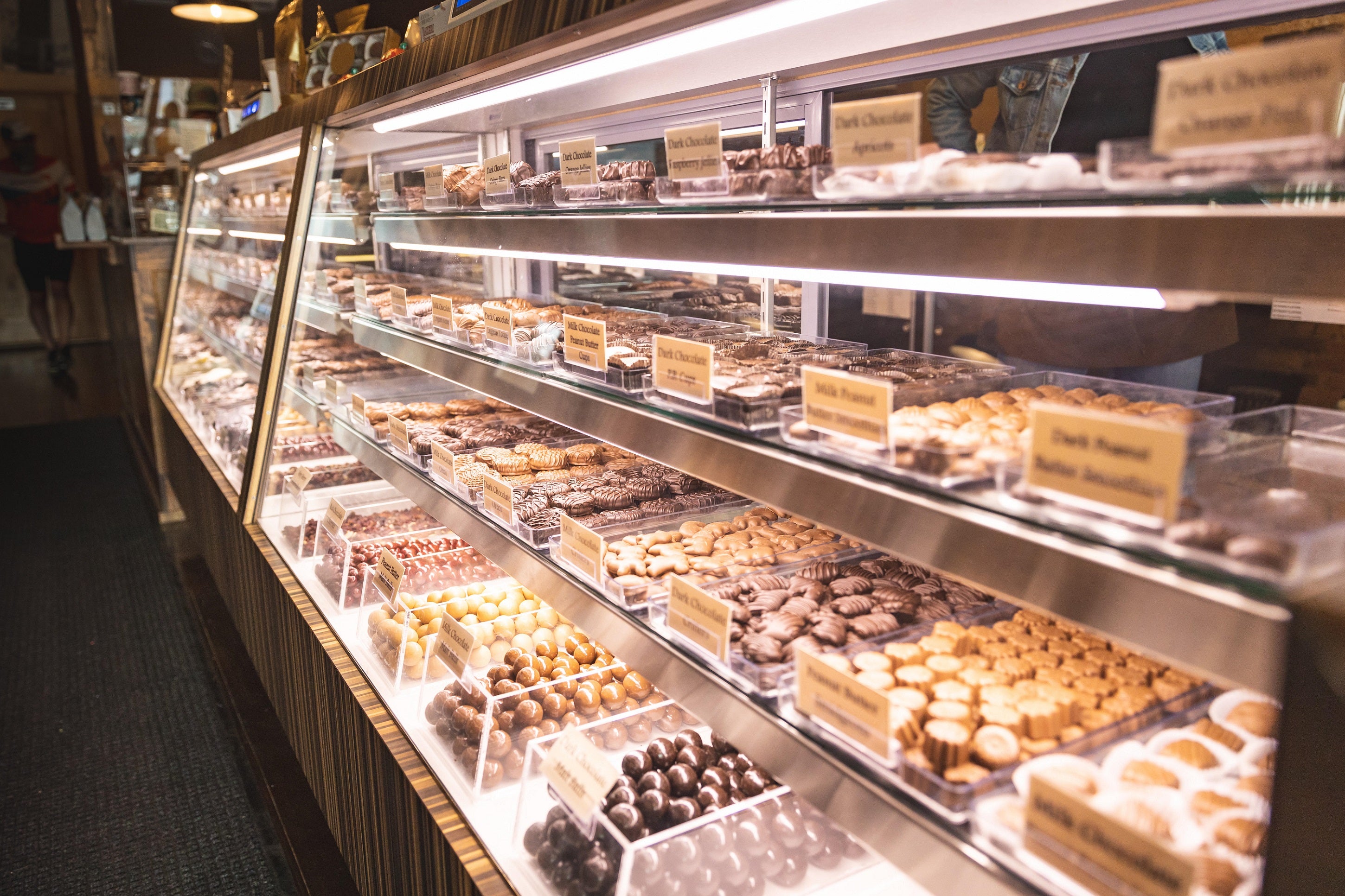 Illuminated case of assorted chocolate candies at Sweetland Candies Rockford, Michigan location