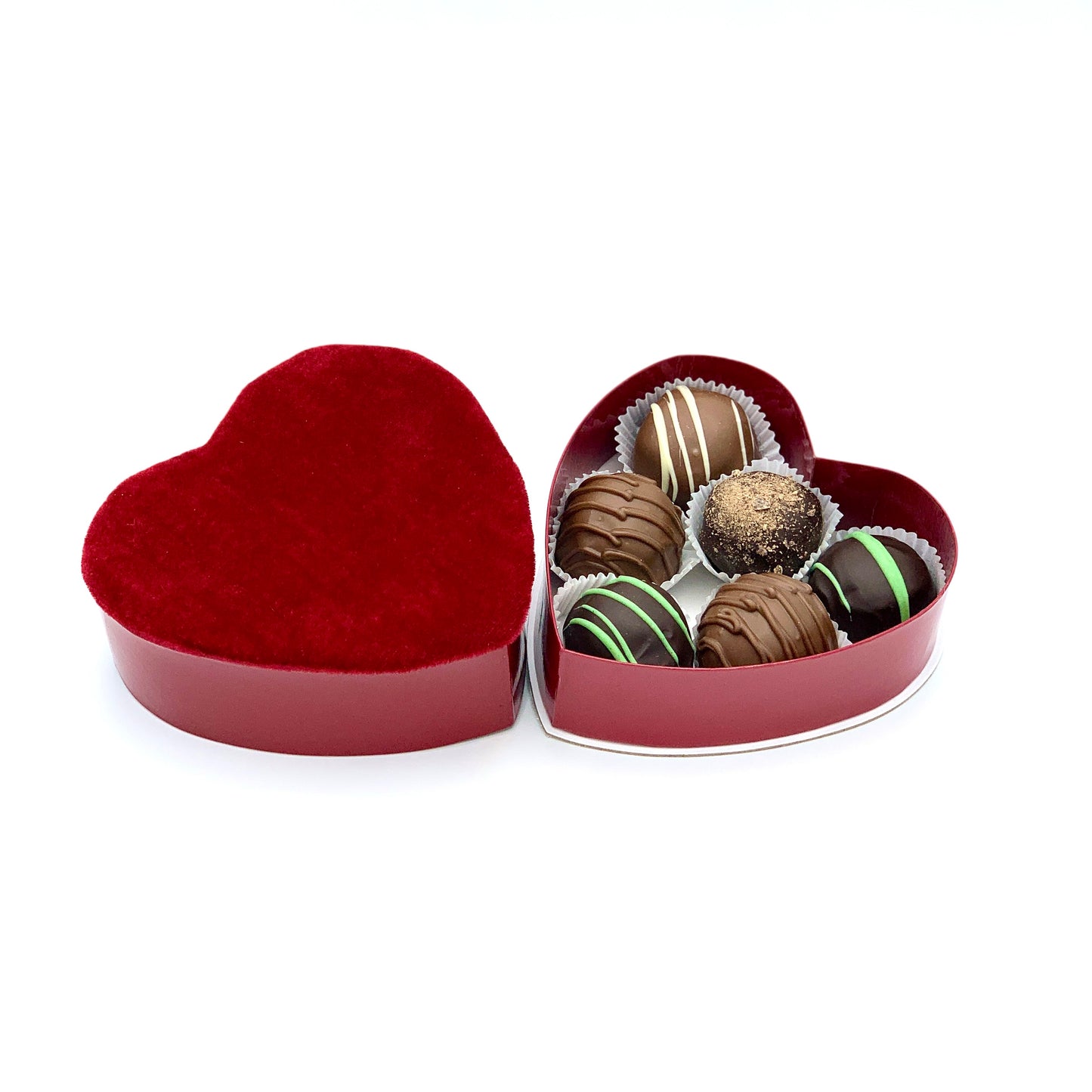  A red heart-shaped box filled with assorted chocolate truffles, elegantly presented for a romantic gift.